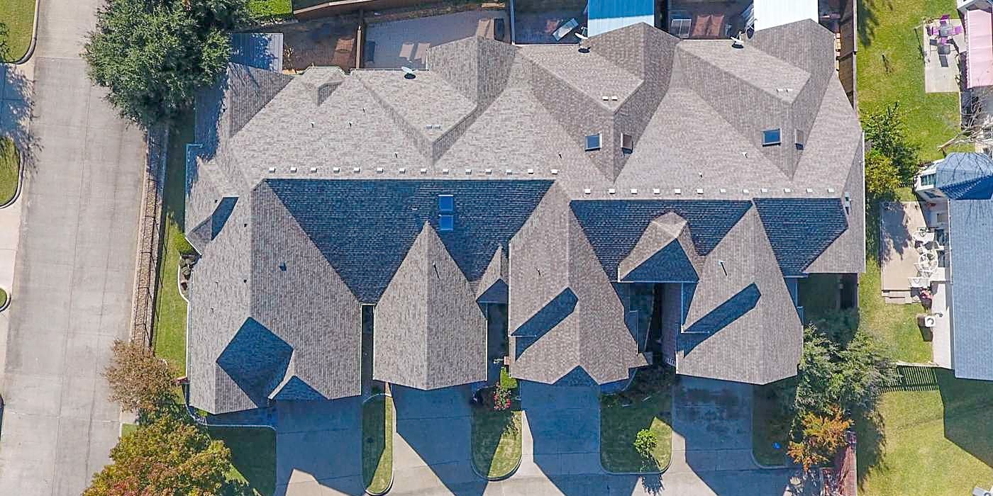 A roof with many hips and valleys in two-tone shingles, from above