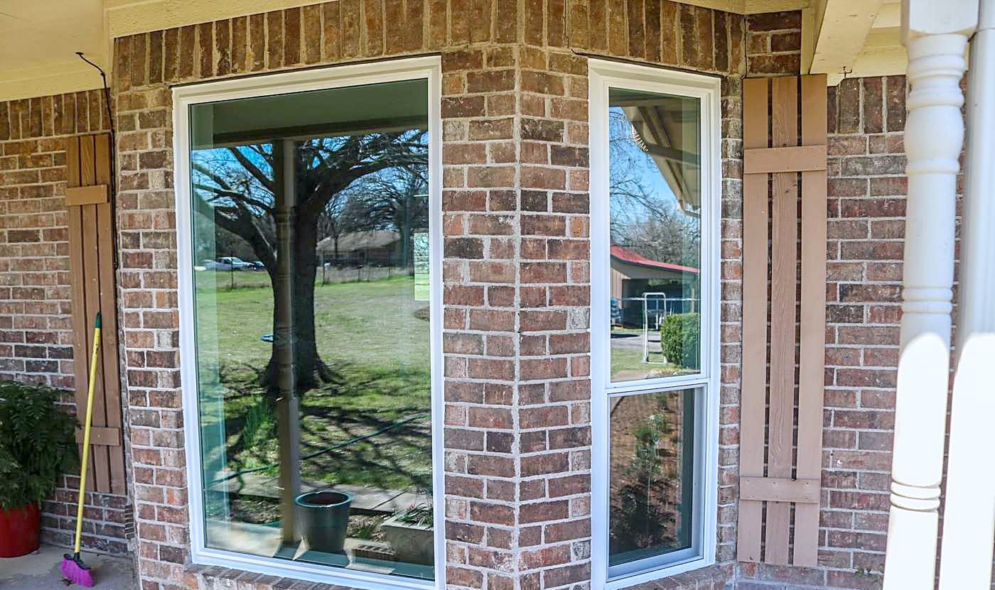 New white-framed windows set into a brick bay